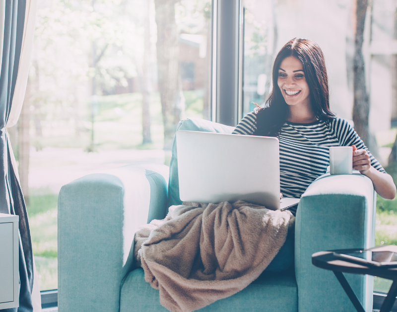 woman working on laptop with fast wi-fi in airbnb with coffee smiling