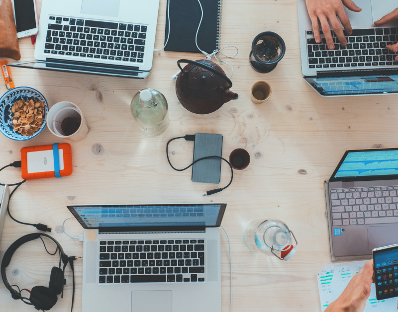 airbnb guests working at table with multiple laptops and phones