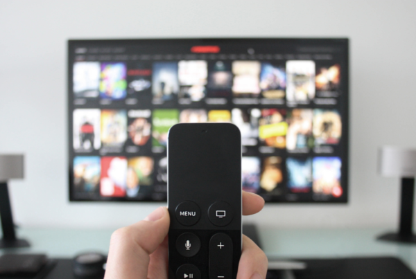 hand holding remote changing smart tv channel selecting netflix